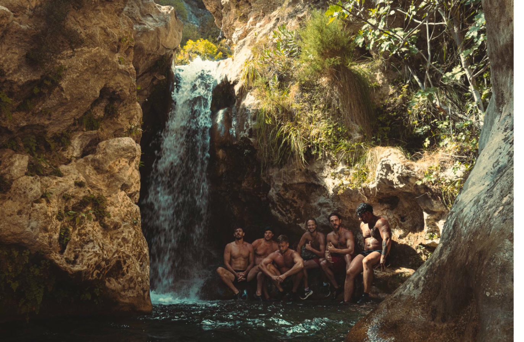 Wildman brotherhood resting beneath a canyon waterfall